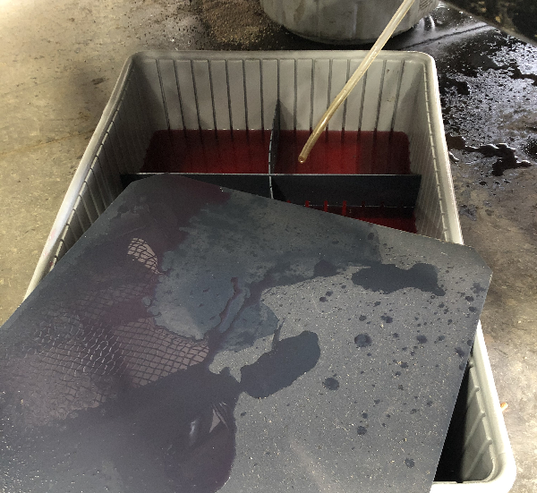 Save-A-Spill container holding coolant under its protective cover with divider baffles