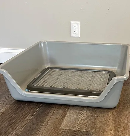 Shirley K's dog litter box with a pee pad holder inside